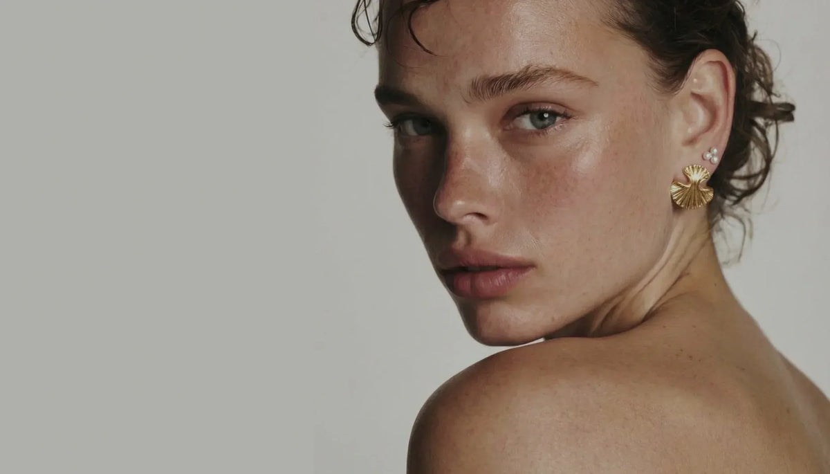 Woman with clear, even skin texture looking over her shoulder